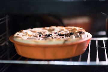 Raw vegan sweet tart, pie or cake with blueberries currants, coconut, dates, bananas, oil, cocoa powder and cashew cream on a silicone plate in the oven . Organic product.
