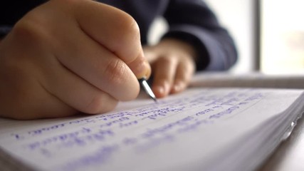 Child hands writing a letter, close up 4K - Powered by Adobe