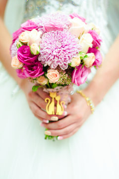 young bride in a beautiful dress holding a bouquet in hands