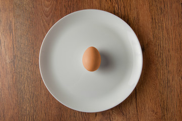 Yellow Brown egg on white dish on dark wood table