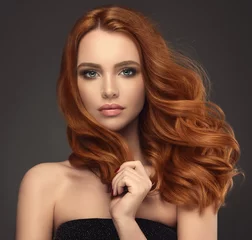 Foto op Plexiglas Kapsalon Beautiful model girl with long red curly hair .Red head . Care and beauty hair products 