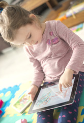 little girl is using a digital tablet