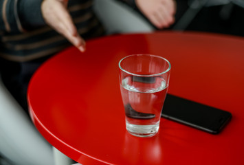 Glass of water on a red table