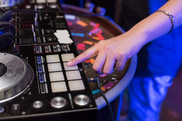 Music Concepts. DJ is rhythm music with Controller and mixer. DJ is playing the song at the party. Young are adjusting the music with the controller. The fun of music and light colors.