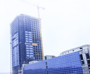 building, skyscraper. It is made of concrete and glass. Crane in the open