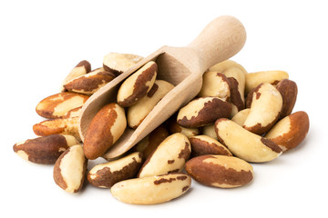 Bunch of Brazilian nuts and wooden scoop on a white background.