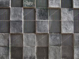 grey concrete wall with geometric square pattern and distressed textures