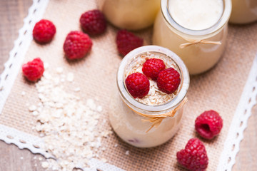 Jars with yogurt, raspberries and oat flakes 