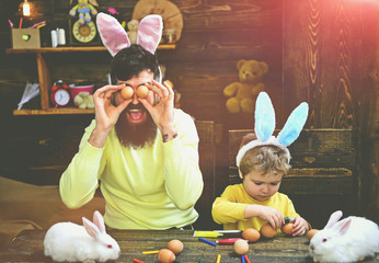 Child and father holding basket with painted eggs.