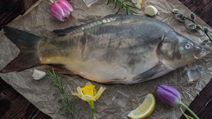 carp for the festive Easter table with rosemary and lemon on crumpled paper.