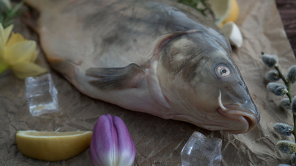 carp for the festive Easter table with rosemary and lemon on crumpled paper.