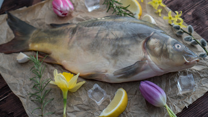 carp for the festive Easter table with rosemary and lemon on crumpled paper.