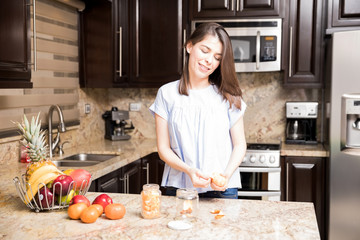 Woman storing separated orange portions in bottles