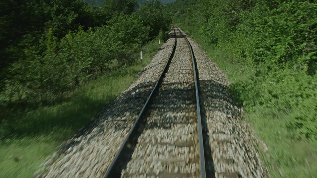 A on board shot of a train passing through some woods.