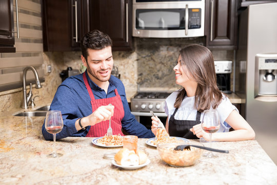 Happy couple having meal together in kitchen