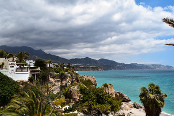 Landscape with sea, beach, mountains, house and cloudy sky