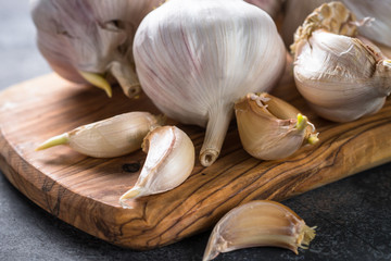 Garlic cloves on a dark stone background. 