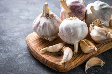 Garlic cloves on a dark stone background. 