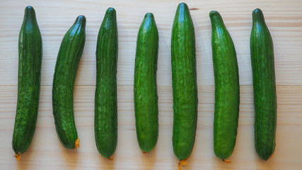 Cucumbers on light wooden background.
