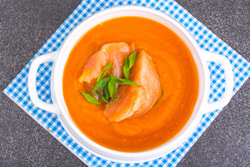 Carrot, pumpkin cream soup with salmon