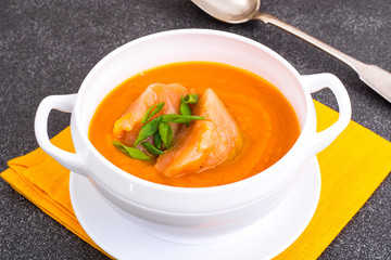 Carrot, pumpkin cream soup with salmon