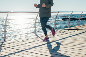A slender young woman runs on seaside