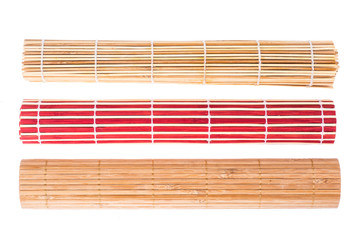 Bamboo mats of different colors on white background