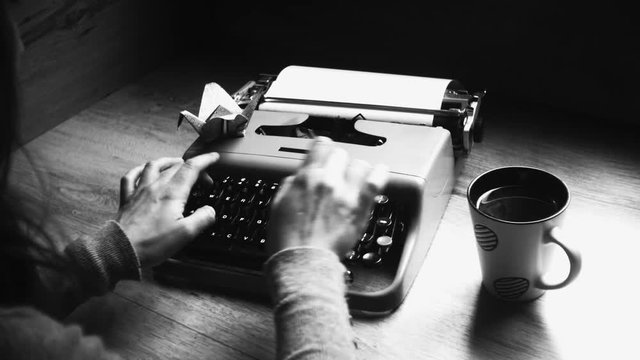Person typing on a vintage typewriter with vintage 35mm camera, after an adventurous trip, Taking notes and ideas . Different styles available in my gallery color and Black and white