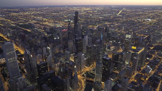 Chicago downtown aerial view passing over the Chicago River with Willis Tower center focused at dusk