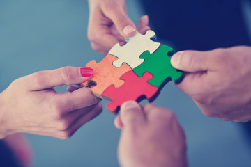 Group of business people assembling jigsaw puzzle
