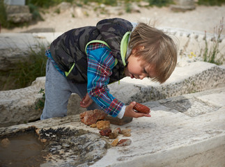 Kid playing with stones on Acropolis