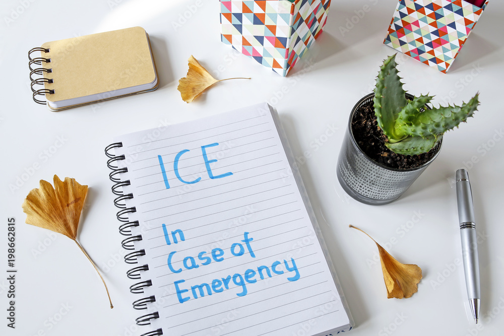 Poster ice in case of emergency written in notebook on white table