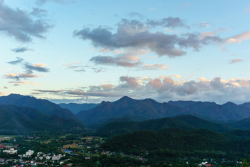 Amazing local city and wild nature view of layer of mountain forest landscape with cloudy sky at winter season. Natural green scenery of cloud and mountain slopes background. Maehongson,Thailand
