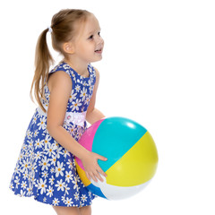 Little girl is playing with a ball