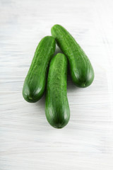 fresh green cucumbers on white wooden kitchen plate, can be used as background