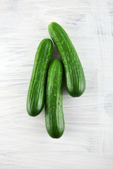fresh green cucumbers on white wooden kitchen plate, can be used as background