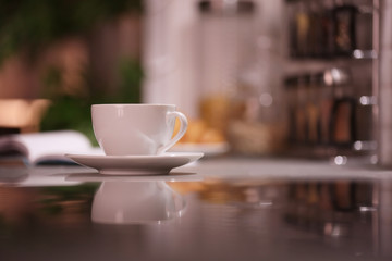 Cup of hot coffee on blurred background