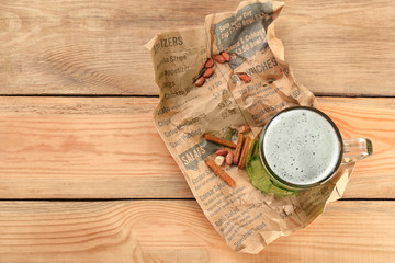 Glass of green beer on wooden background, top view. Saint Patrick's day celebration