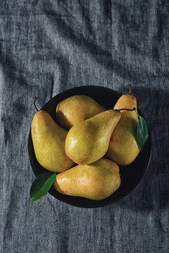 Bowl with fresh ripe pears on cloth