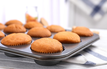 Baking tray with tasty cupcakes on table. Fresh from oven