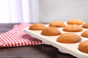 Baking tray with tasty cupcakes on table. Fresh from oven