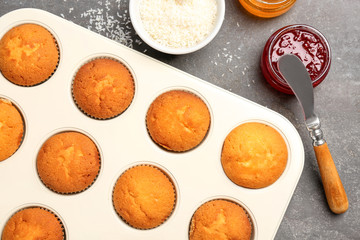 Baking tray with tasty cupcakes on table. Fresh from oven