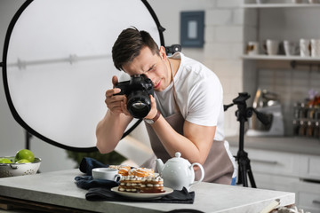 Young man taking picture of food in photo studio