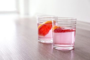 Fototapeta na wymiar Glasses of fresh lemonade with grapefruit on table