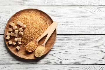 Flat lay composition with brown sugar on wooden table