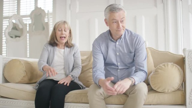 Mature married couple in a dispute as the husband listens to his wife nagging him