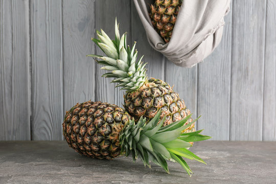 Fresh pineapples on table against wooden wall