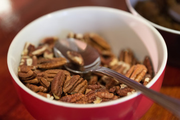 Healthy eating snack concept. Pecan kernel nuts in red with spoon