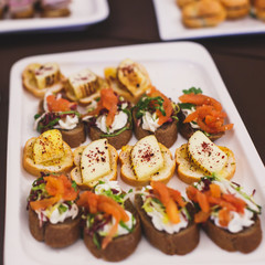 Beautifully decorated catering banquet table with different food snacks and appetizers on corporate christmas birthday party event or wedding celebration
