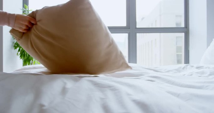 Woman holding pillow in bedroom 
